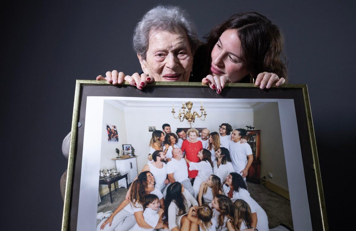 Julia Wallach, holding a family photo in her hands.
