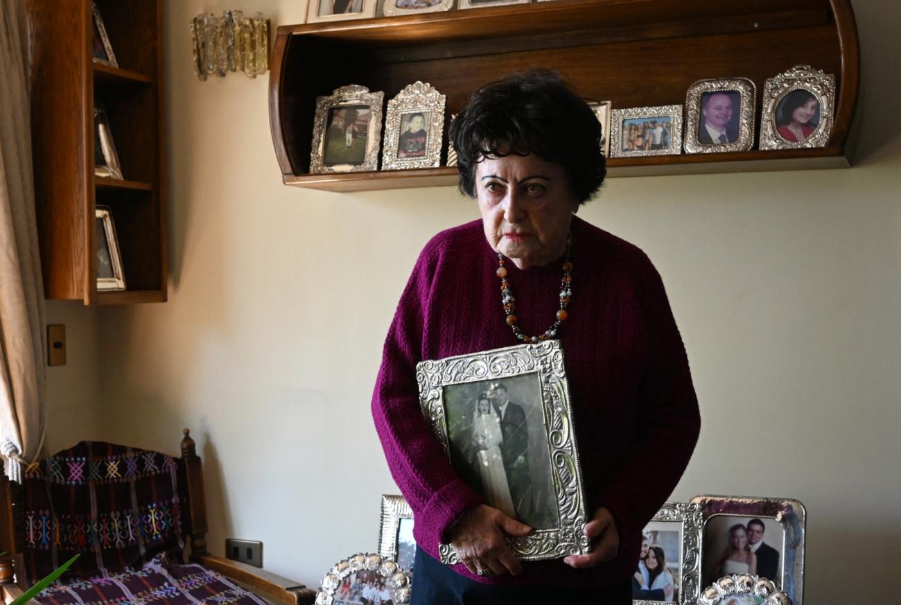 Marta Neuwirth, aged 95, holds a black and white family portrait in her hands.