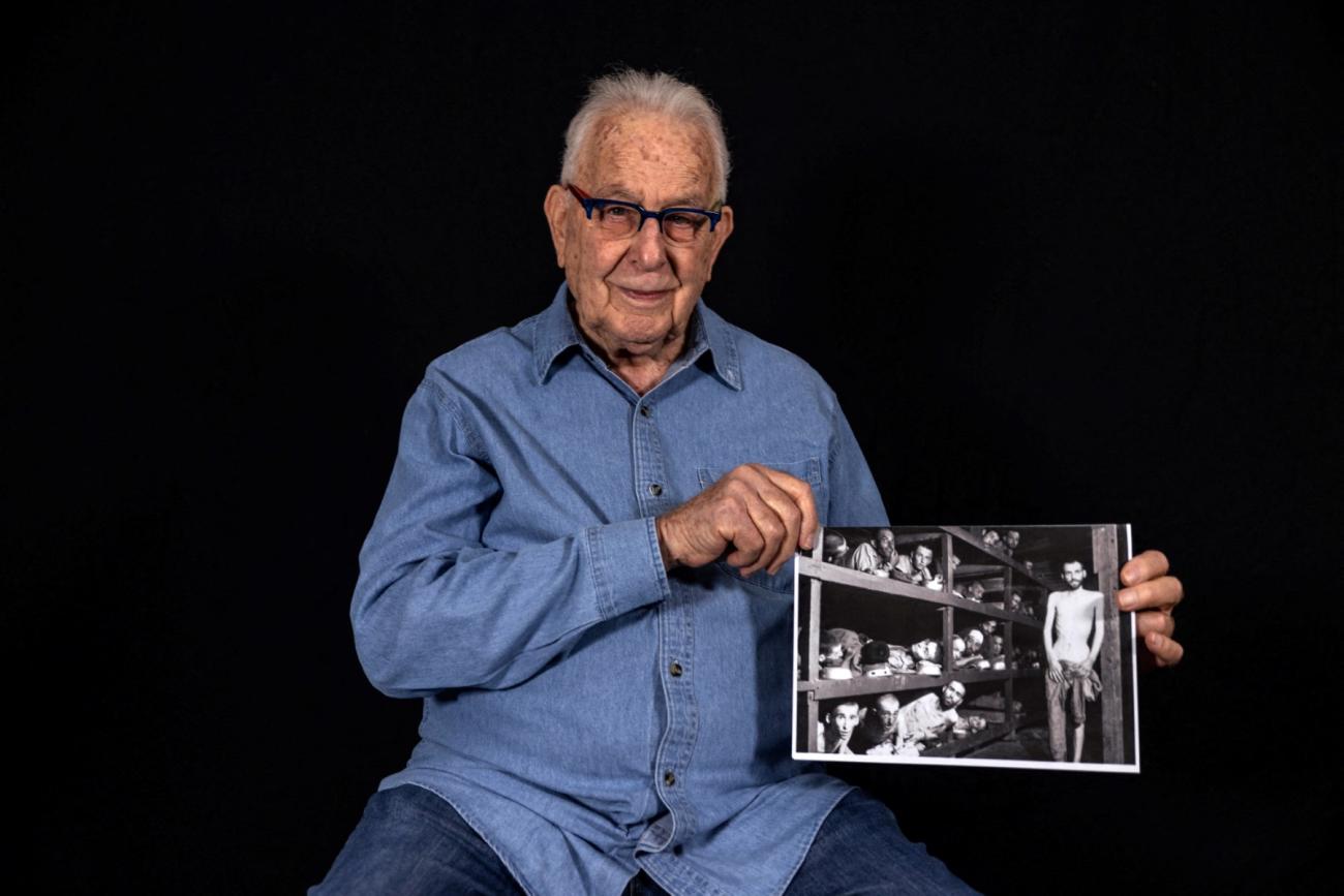 Naftali Fürst holds a photo of a concentration camp in his hands.